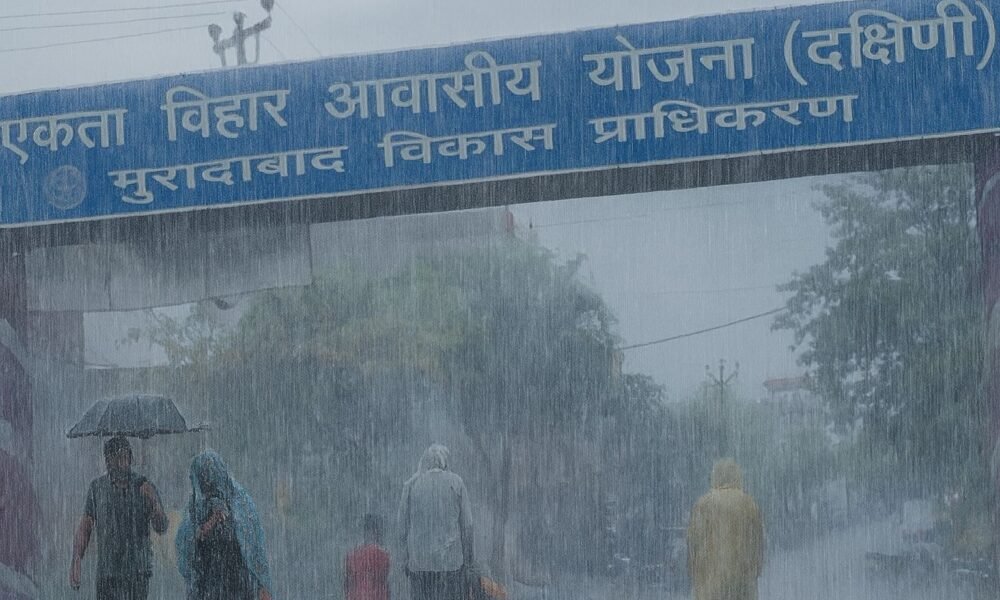 एकता विहार (मुरादाबाद) में बारिश के बाद कीचड़ से भरी गलियां और छाता लिए लोग