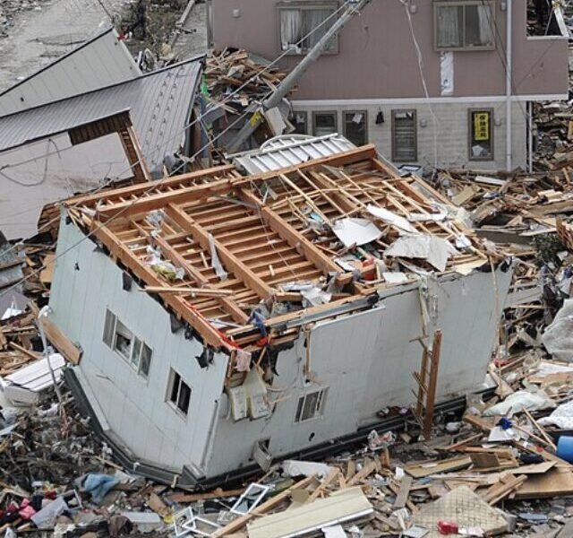 US_Navy_110315-N-2653B-107_An_upended_house_is_among_debris_in_Ofunato,_Japan,_following_a_9.0_magnitude_earthquake_and_subsequent_tsunami