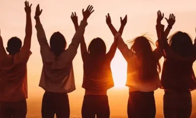 group-friends-standing-hilltop-rejoicing-raising-their-hands-air-with-beautiful-sunset-background.jpg