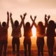 group-friends-standing-hilltop-rejoicing-raising-their-hands-air-with-beautiful-sunset-background.jpg